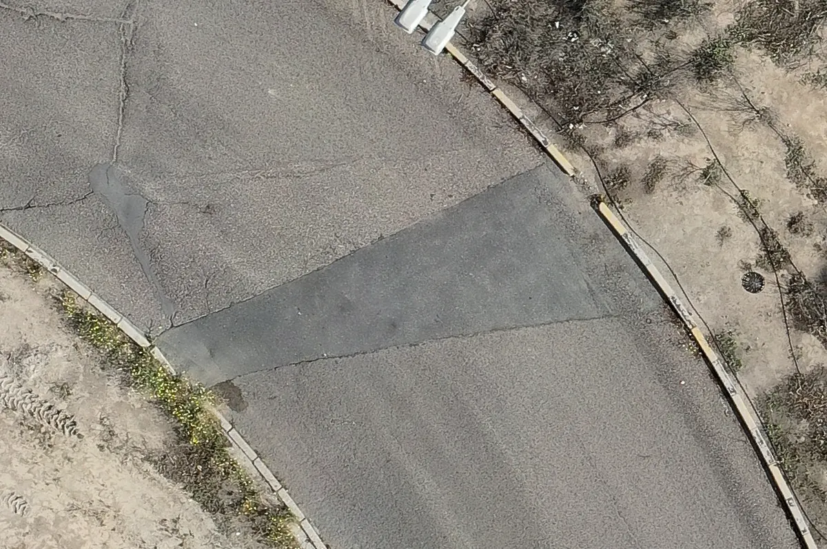 Patched section of asphalt at the kerb, outlined
